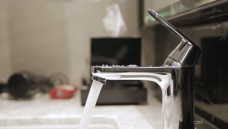 Turn-on-running-water-flows-from-the-tap-to-the-white-sink-and-turn-off