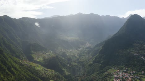 Toma-De-Drones-De-Un-Valle-Escarpado-Y-Vasto-En-Madeira-Con-Un-Pequeño-Pueblo