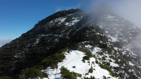 A-single-woman-is-walking-on-the-snowy-trail-of-the-mountain-Pico-Ruivo-in-Madeira