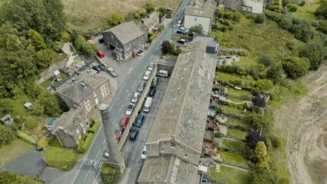 Street-Aerial-footage-of-a-industrial-rural-village-with-old-mill-and-chimney-stack-surrounded-by-fields