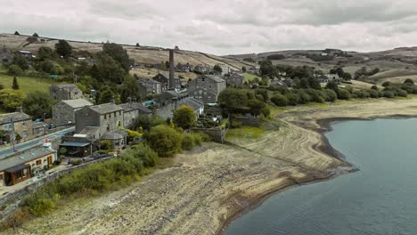 Aerial-video-of-a-industrial-rural-village-with-old-mill-and-chimney-stack-surrounded-by-fields