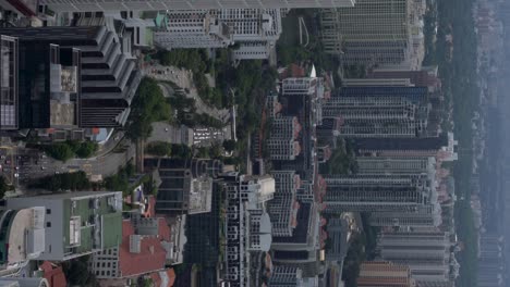 Vertical-video---Densely-populated-downtown-Singapore,-cityscape-including-many-skyscrapers-and-street-traffic