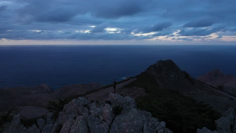 Single-person-standing-alone-after-sunset-on-top-of-a-mountain-in-the-dark-in-Porto-Santo,-Madeira