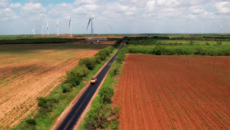 Jeep-truck-coming-down-country-road-in-a-wind-farm