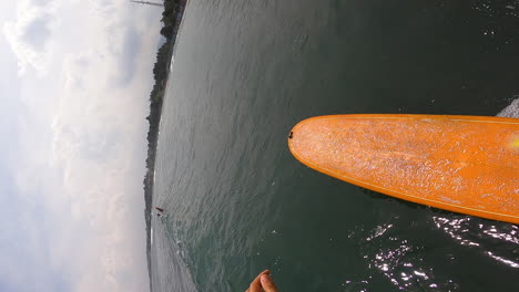 POV-surfing-in-Bali-with-orange-surfboard,-moody-cloudy-day
