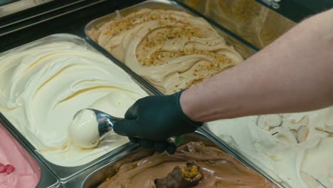 Scooping-a-gelato-ice-cream-from-a-showcase-in-ice-cream-shop