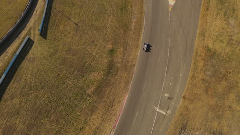 A-dynamic-tilting-aerial-shot-while-tracking-a-running-race-car-passing-below-the-drone