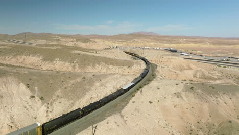 Aerial-View-Of-Long-Cargo-Train-Passing-Through-Nevada-State-In-The-USA---drone-shot