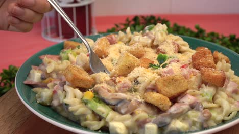 Pasta-salad-with-fork-in-slow-motion-tasting-hand