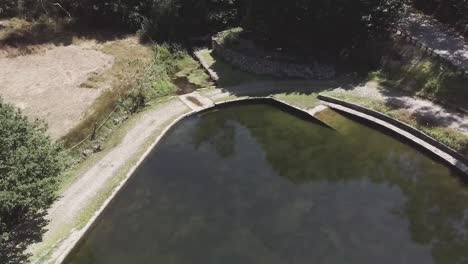 Aerial-shot-of-a-lake-behind-trees-in-Águeda,-Portugal