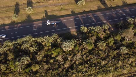 Luftaufnahmen-Eines-Leeren-Abschleppwagens,-Der-Bei-Sonnenuntergang-Auf-Einer-Ländlichen-Strecke-In-Uruguay,-Südamerika,-Fährt