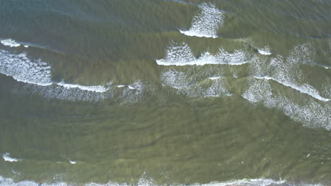Aerial-top-down-shot-of-breaking-waves-in-Baltic-Sea-during-sunny-day
