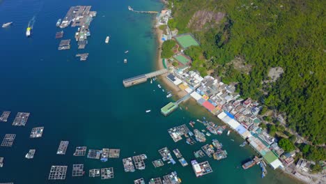 Drone-shot-orbiting-above-a-small-fisher-village-with-a-dock-and-oysters-farm-during-the-day