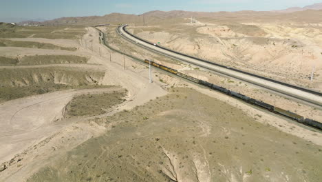 Long-Freight-Train-Traveling-Through-State-Of-Nevada-In-USA---aerial-drone-shot