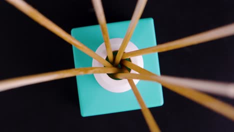 Birdseye-shot-of-a-rotating-room-fragrance-diffuser-with-wooden-sticks-in-turquoise
