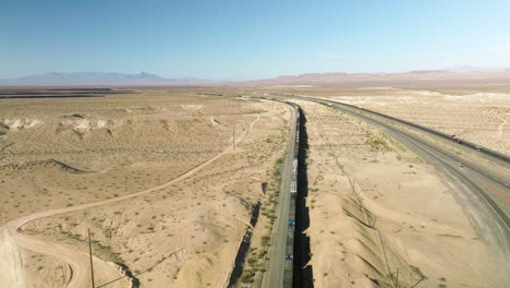 Long-Freight-Train-On-Tracks-Crossing-Desert-Landscape-In-Nevada,-USA