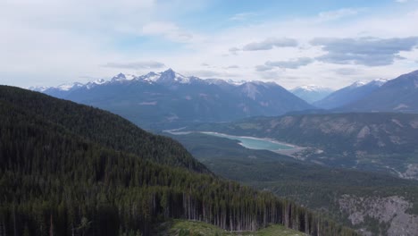 Represa-Hidroeléctrica-En-Un-Enorme-Paisaje-Montañoso-Con-árboles-Nevados-Y-Un-Cielo-Azul-Brillante-Con-Drones-Aéreos-Panorámicos-En-Canadá-Bc-4k