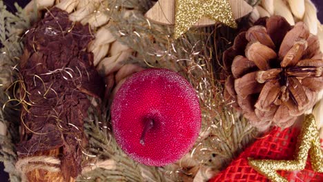 Close-up-of-rotating-decoration-for-christmas-with-pine-cone-wood-and-pomegranate-in-the-middle-and-a-star