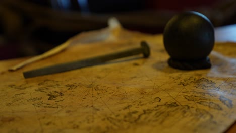 Close-up-old-naval-map-with-cannon-ball-and-nail