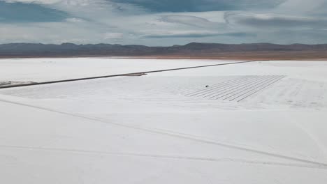 Aerial-drone-shot-of-the-Argentinian-white-Salt-Flats-closing-into-the-crystal-light-blue-colors-of-the-water-pools