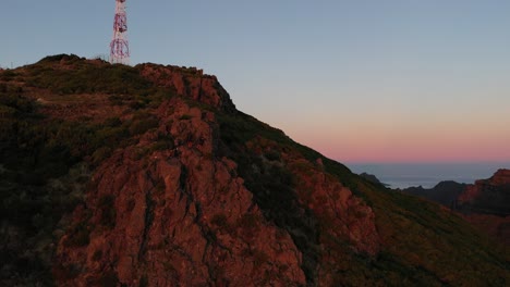 Drohnenclip-Eines-Gipfels-Mit-Funkturm-Auf-Madeira-Während-Der-Ersten-Sonnenstrahlen-Am-Morgen-Mit-Buntem-Himmel