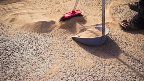 High-FPS,-sweeping-sand-from-pavement-in-an-arid-dry-surface-during-a-hot-summer-sunny-day-in-Spain