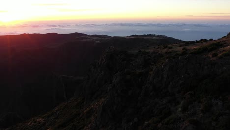 Clip-De-Drones-Sobre-El-Borde-De-Una-Montaña-Durante-Los-Primeros-Rayos-Del-Amanecer-En-Madeira