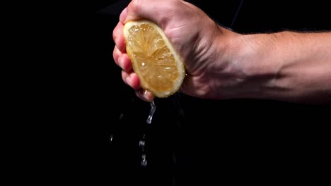Male-hand-squeezes-juicy-lemon-to-make-lemonade