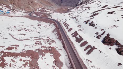 Fahrzeuge,-Die-Im-Paso-Internacional-Los-Libertadores-Mit-Schneebedeckten-Berghügeln-Im-Winter-In-Portillo,-Chile-Fahren
