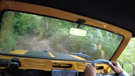 POV-Driving-up-a-bumpy-road-in-a-yellow-Jeep-in-Bali,-Indonesia