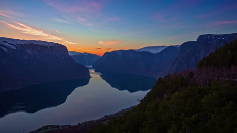 Sunset-To-Night-Timelapse-Over-The-Calm-Lake-And-Mountains