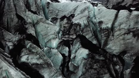 Aerial-view-of-the-textured-ice-of-Sólheimajökull-glacier,-Iceland,-in-summer