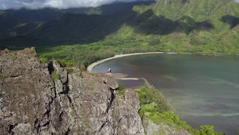 Hikers-On-Crouching-Lion-Mountain-Peak-With-Huilua-Fishpond,-Kahana-Bay-Beach-And-Ahupuaʻa-ʻO-Kahana-State-Park-In-The-Background-in-Oahu,-Hawaii