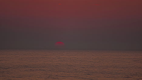 Leuchtend-Orangefarbene-Sonne,-Die-Bei-Sonnenaufgang-über-Dem-Meer-Aufgeht