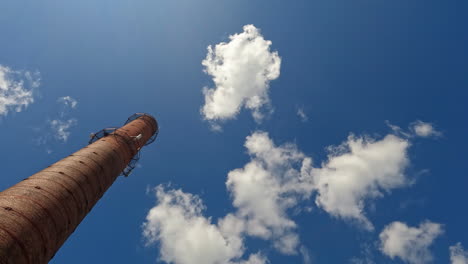 Old-Chimney-With-Fluffy-Clouds-And-Blue-Sky-In-The-Background