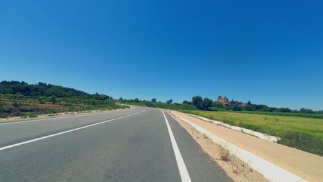 POV-shot-from-the-handlebars-of-a-road-cyclist-riding-along-the-Spanish-countryside-on-a-sunny-day,-Catalunya,-Spain