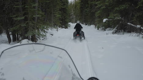 Snowmobiling-through-woods-in-the-winter