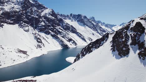 Lago-Escénico-Rodeado-De-Montañas-Rocosas-Nevadas-En-La-Estación-De-Esquí-De-Portillo,-Montañas-De-Los-Andes-De-Chile