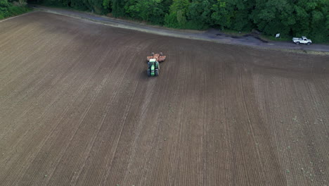 Static-aerial-shot-of-a-farmer-plowing-his-field
