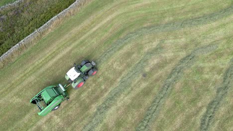 Aerial-footage-of-a-tractor-drives-across-field-and-makes-bales-from-cut-straw-1