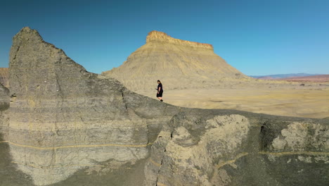 Striking-Scenery-Of-The-Famous-Factory-Butte-In-Utah-With-Male-Tourist-Trekking-On-Badlands-Revealed