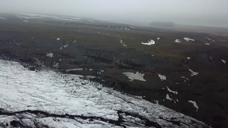 Aerial-landscape-view-of-dark-ice-of-Sólheimajökull-glacier,-Iceland,-during-summer