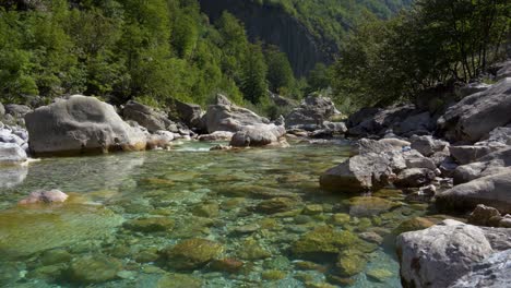 Alpine-river-on-high-mountain-with-turquoise-crystal-cold-water-streaming-through-cliffs