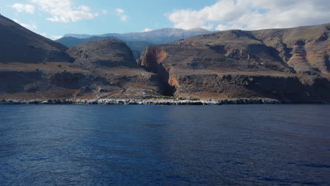 Vista-Desde-Un-Barco-En-Movimiento-De-Un-Paisaje-Montañoso-Y-Volcánico-De-La-Costa-Sur-De-Creta