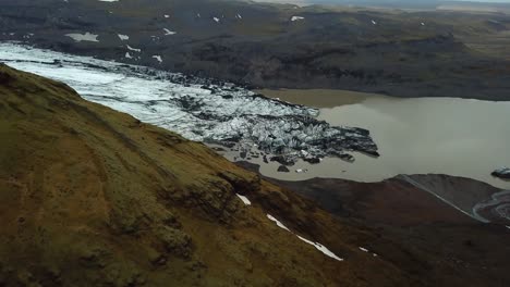 Aerial-landscape-view-of-Sólheimajökull-glacier,-Iceland,-melting-into-water,-during-summer