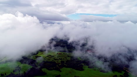 Aerial-flight-through-dense-clouds-and-showing-green-valley-in-countryside