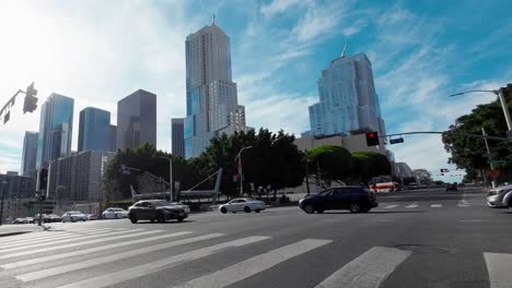 Los-Angeles-City-skyline-on-a-bright-day-with-wispy-clouds-in-the-sky---as-seen-from-a-downtown-intersection
