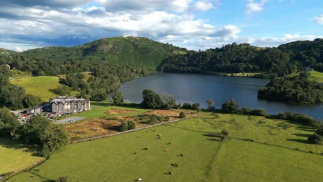 Aerial-video-footage-Grasmere-Village-and-lake,-in-the-Cumbrian-Lake-District-National-Park-England-UK-on-a-beautiful-sunny-day