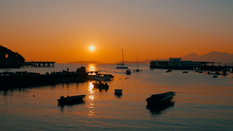 Cinematic-shot-of-a-little-harbor-of-a-little-fisher-village-during-a-beautiful-sunset