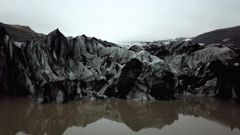 Vista-Aérea-Del-Glaciar-Sólheimajökull,-Derritiéndose-En-El-Agua,-En-Verano,-Islandia